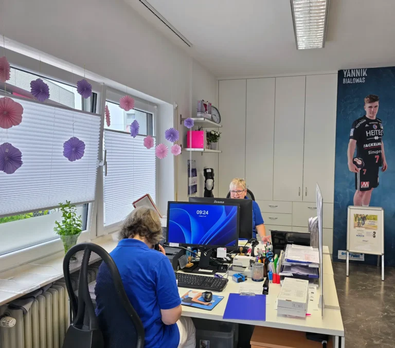 OrthoPoint Erlangen Zentrale, zwei Angestellte sitzen im Büro bei Büroarbeiten