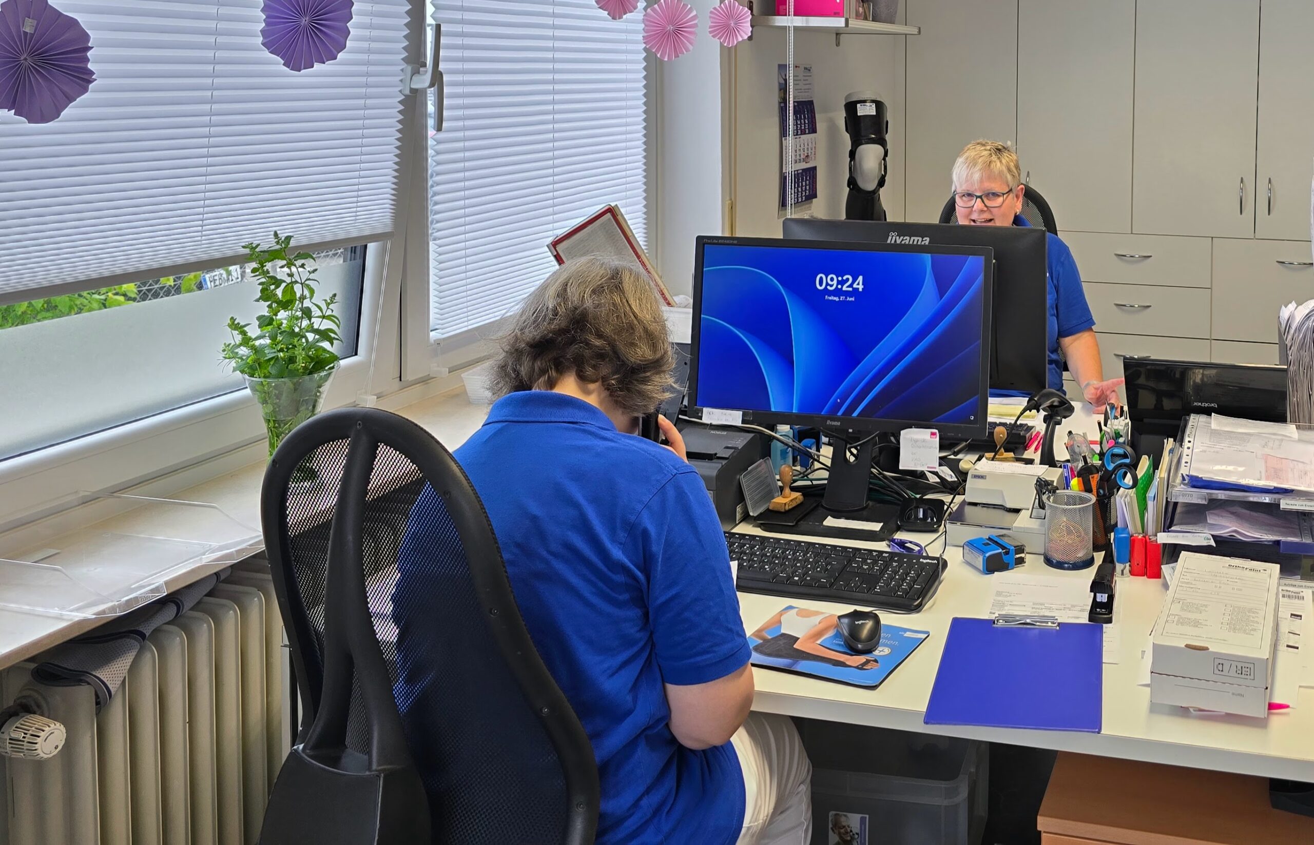 Mitarbeiterin im Sanitätshaus arbeitet am Computer und bearbeitet Kundenanfragen in Erlangen.