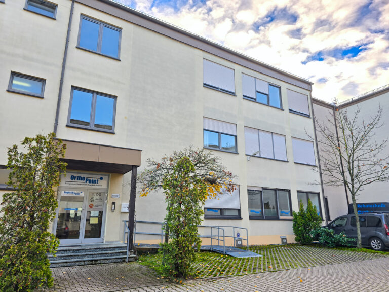 Orthopoint Filiale Wetterkreuz Außenansicht mit Pflanzen und Orthopoint Fuhrpark