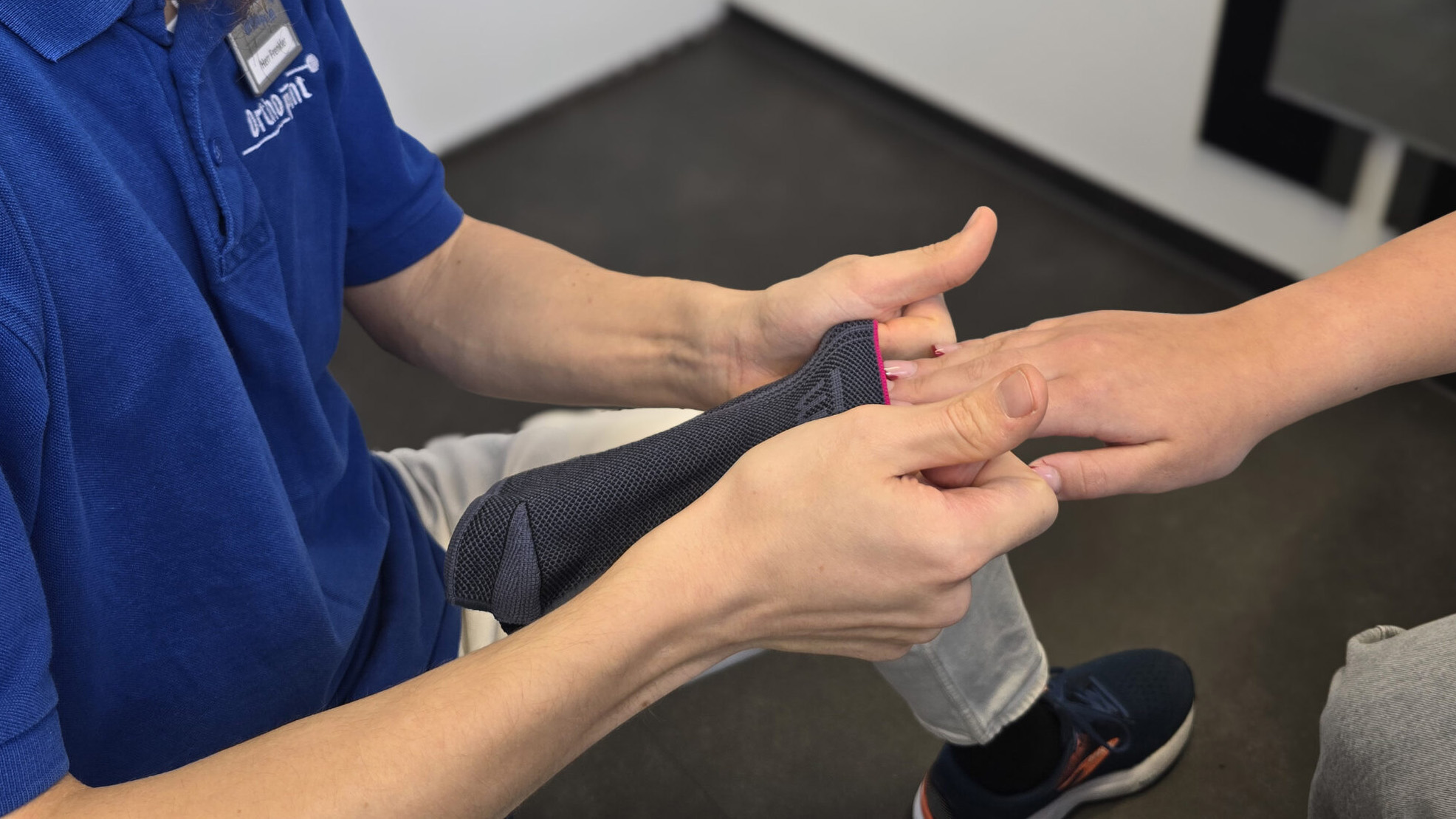 Einer Frau wird eine Handbandage angezogen