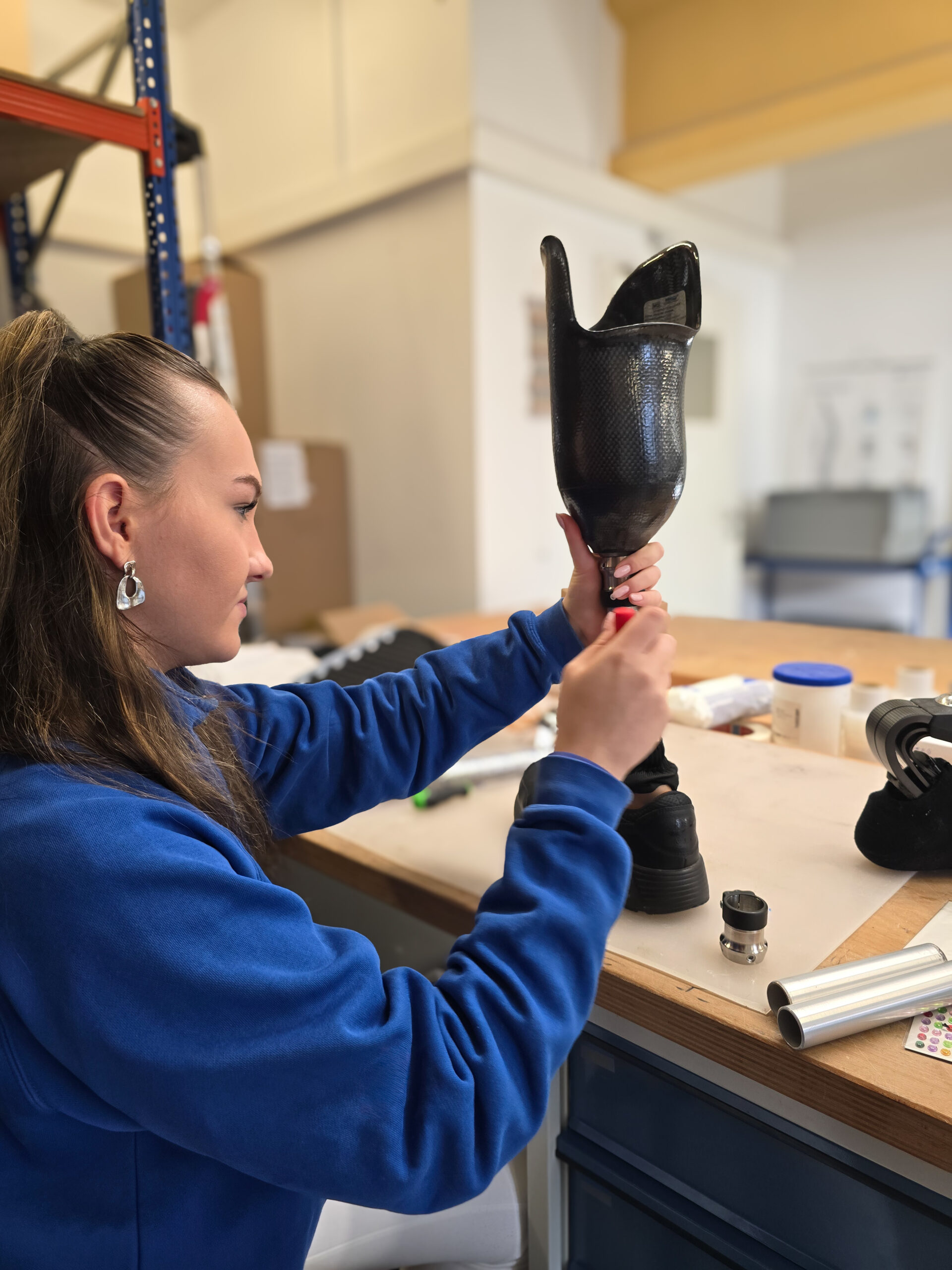 Orthopädietechnikerin überprüft Prothesenschaft während der Anpassung in der Werkstatt von Orthopoint.