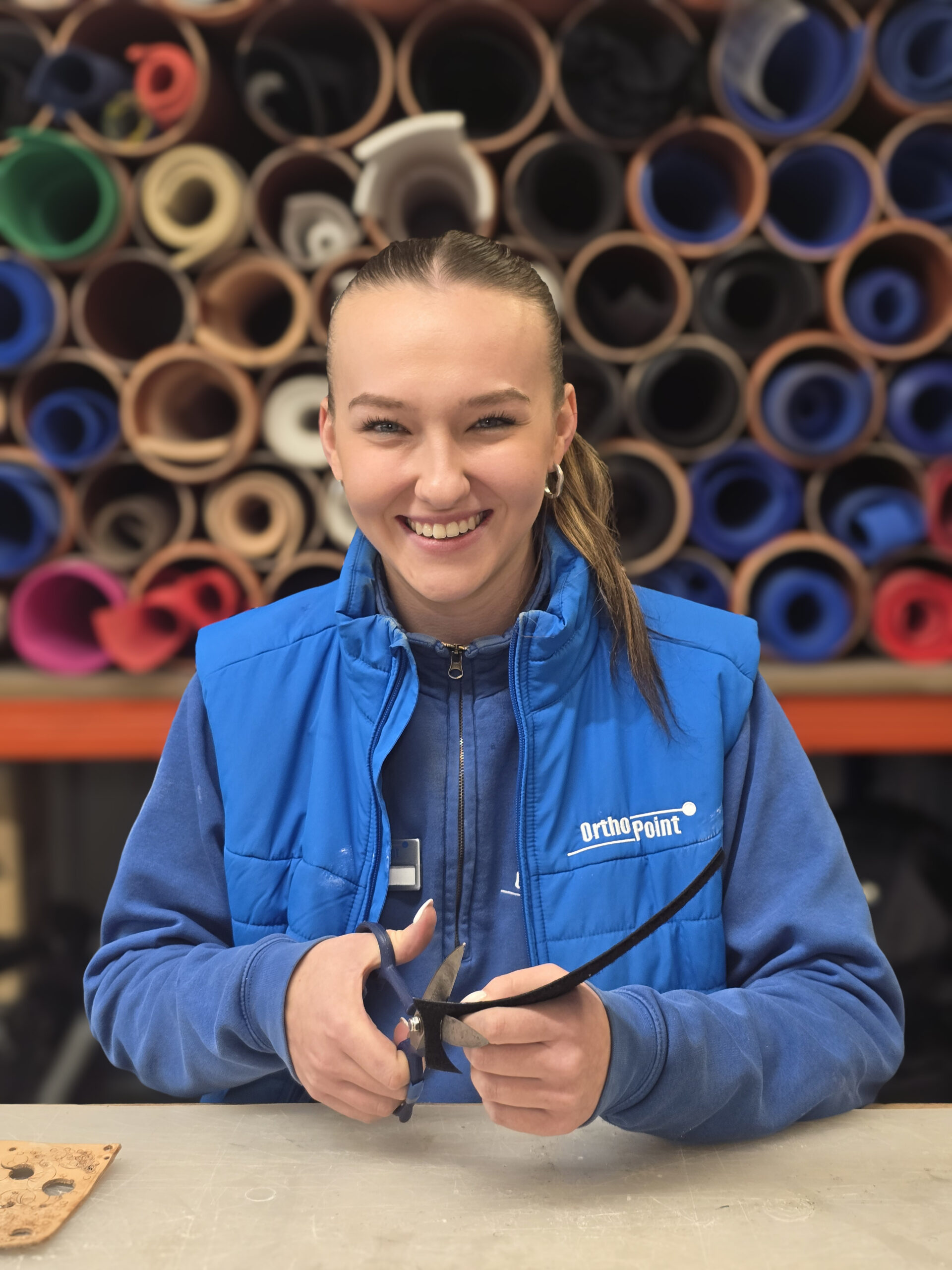 Ehemalige Auszubildende aus der Orthopädietechnik als Portrait während sie eine Einlage schneidet
