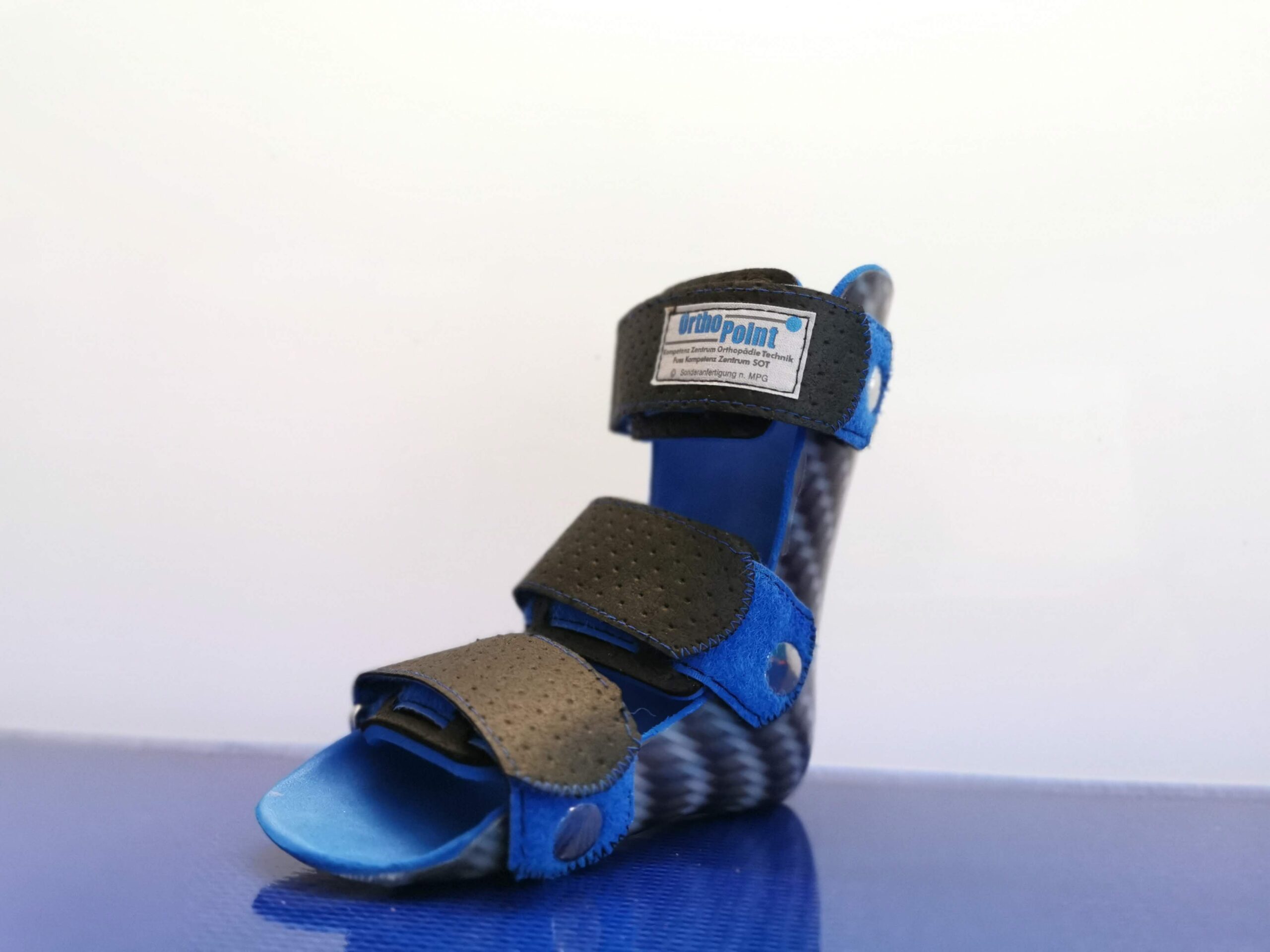 blaue Orthese mit Orthopoint Logo steht auf einer blauen Unterlagen